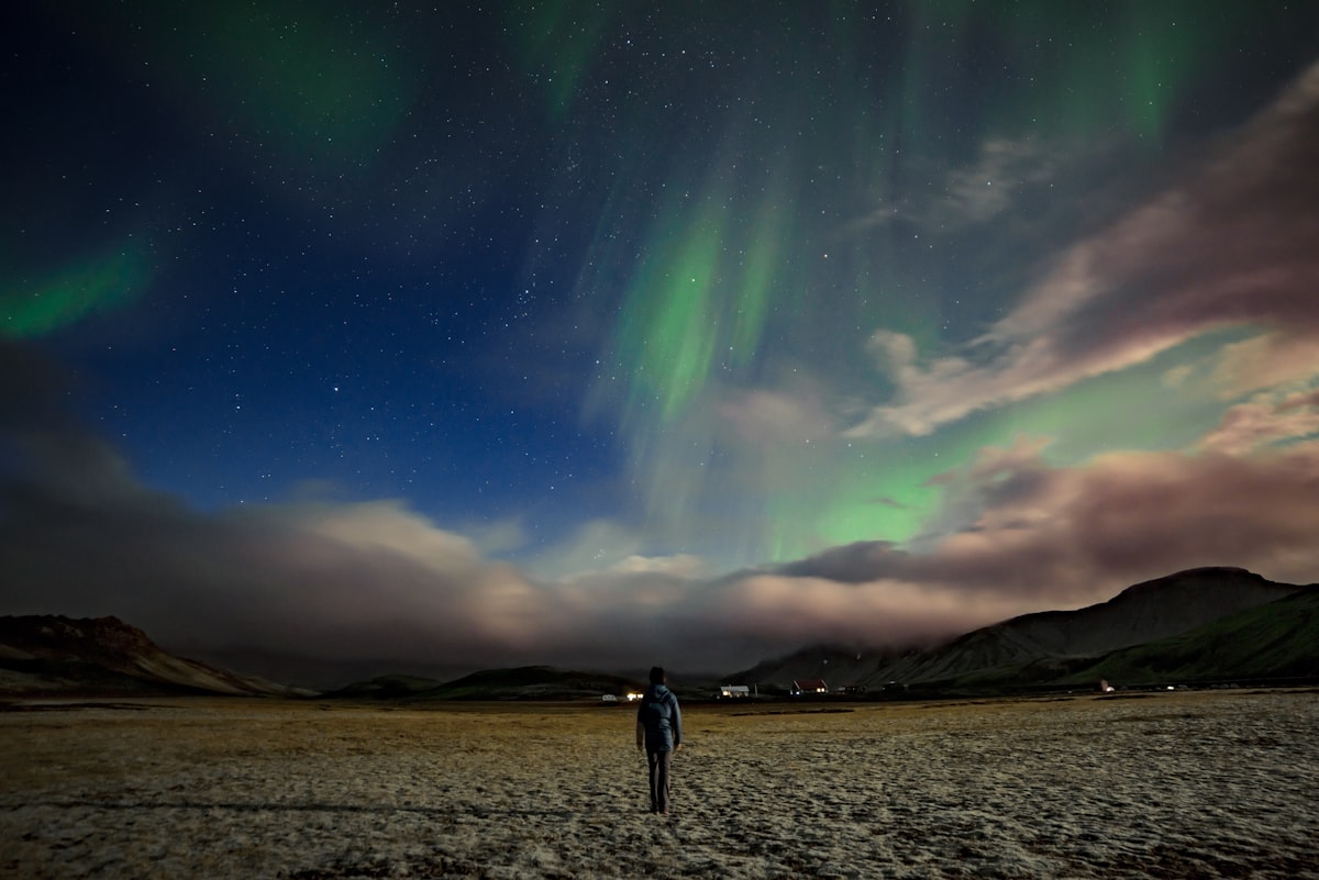 A faint green aurora arc over an Icelandic landscape at the end of summer, the kind of early-season display that appears low on the northern horizon.