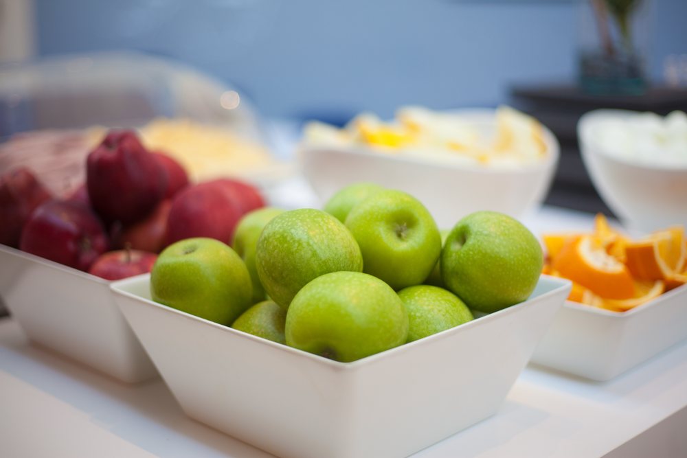 Bowls of green and red apples and sliced oranges on the Reykjavik Lights breakfast buffet